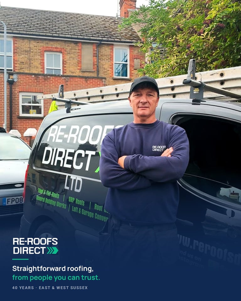 Man in Re-Roofs Direct Ltd uniform standing with arms crossed in front of work van and brick house
